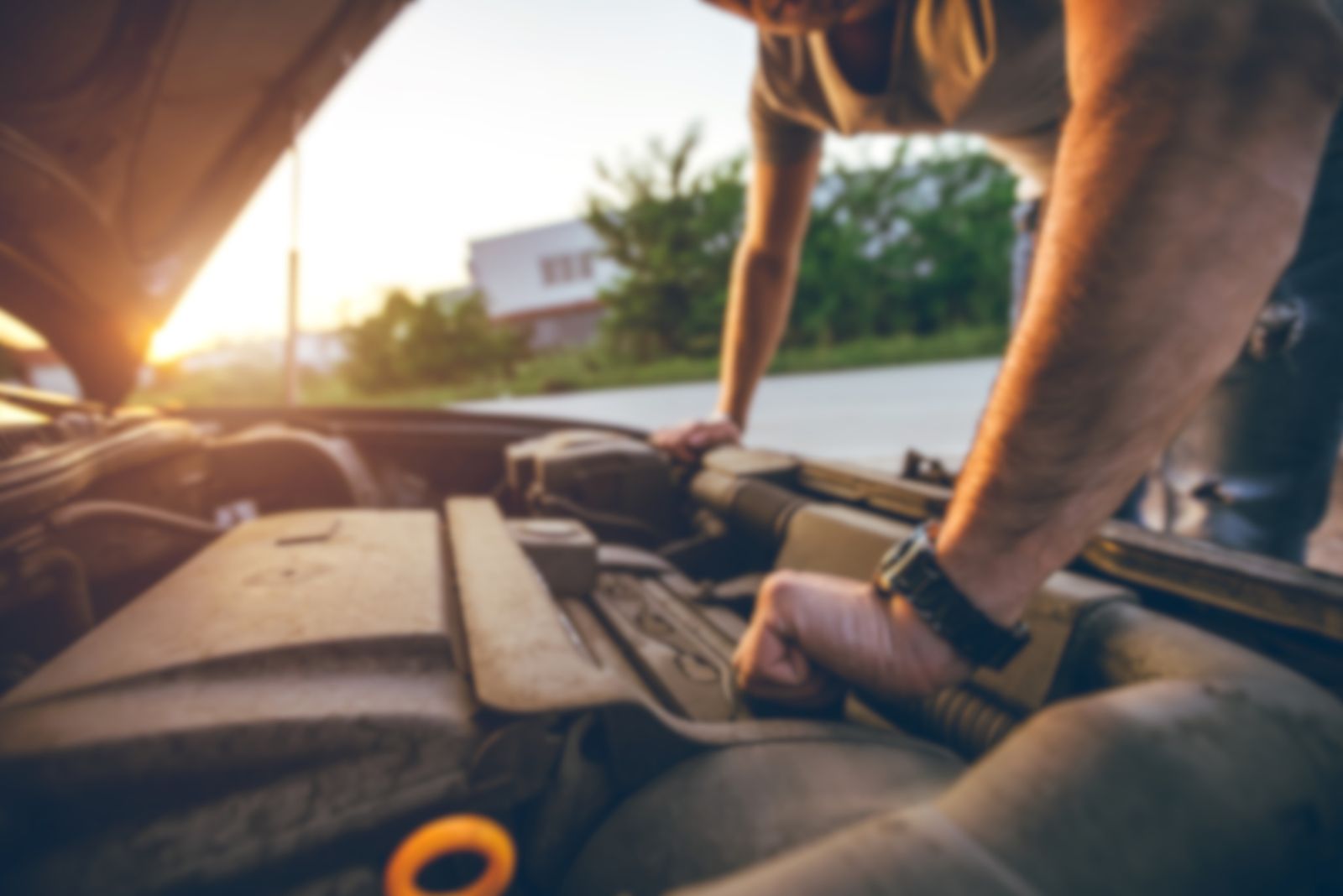 man looking at car engine