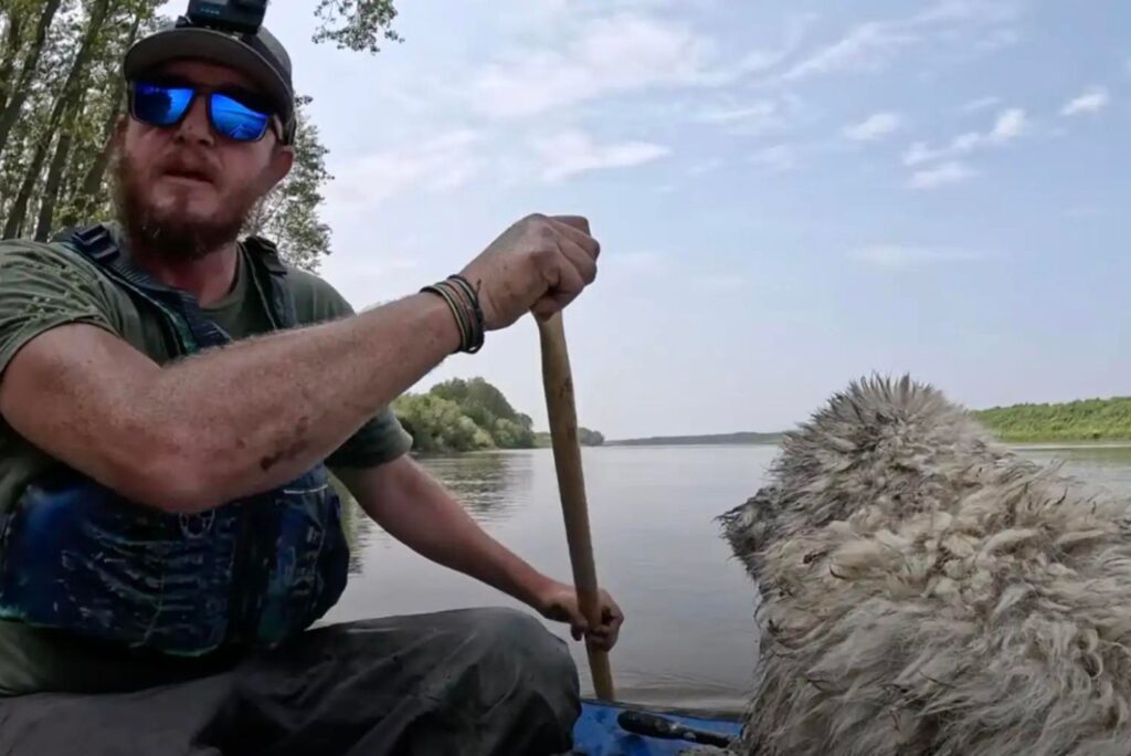 a man in a boat with a dog