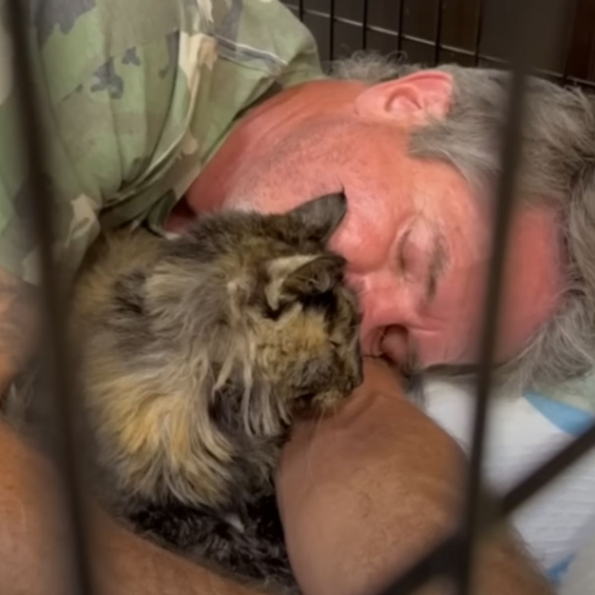 man cuddling with cat