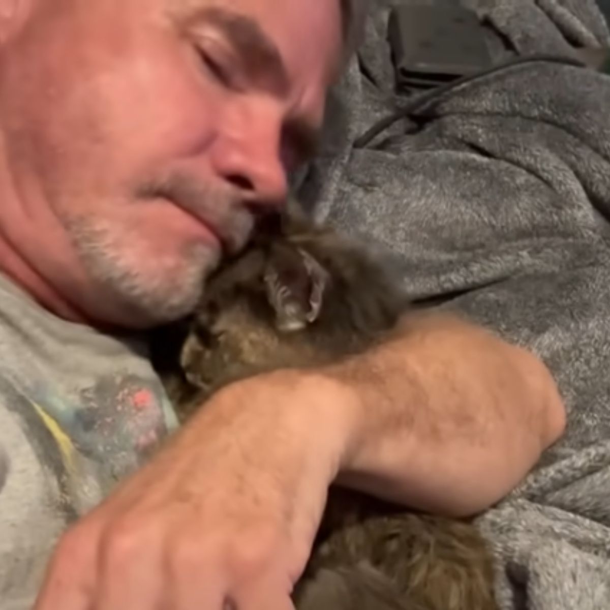 man hugging the cat