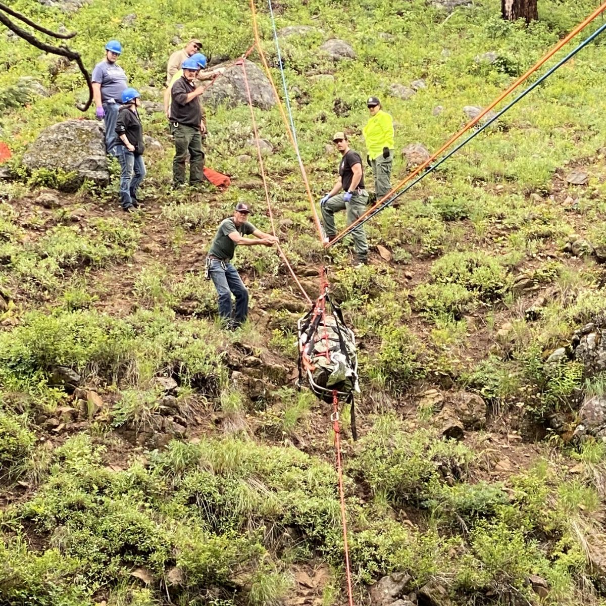 rescuers getting injured man on the ground from the mountain