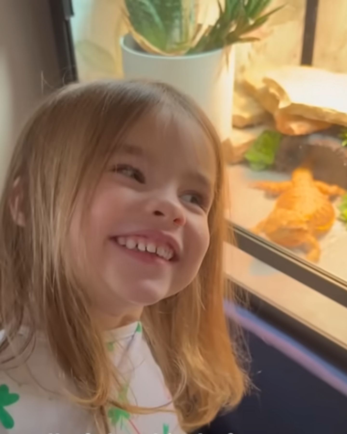 smiling girl looking at bearded dragon