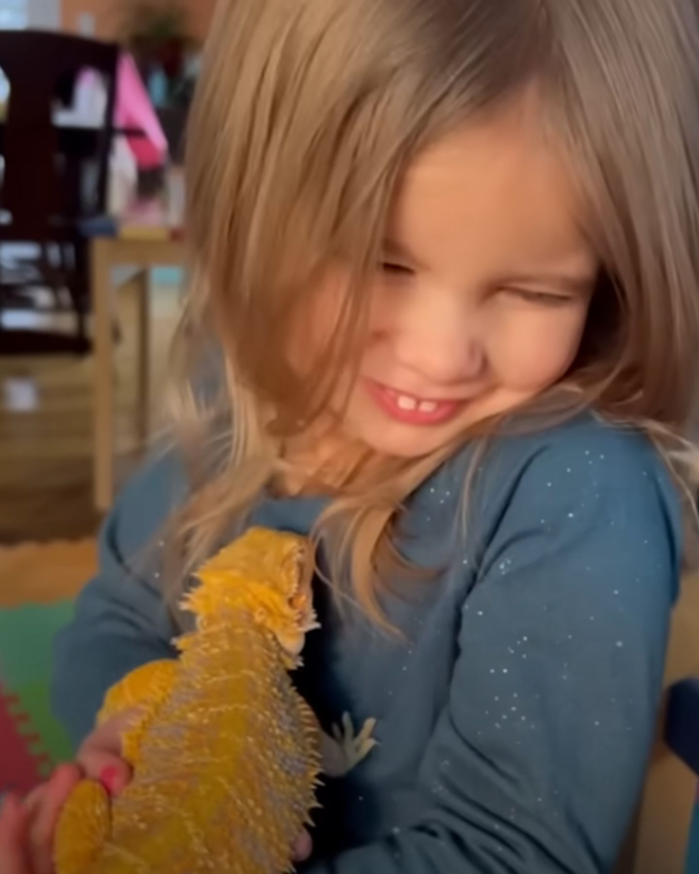 smiling little girl holding bearded dragon