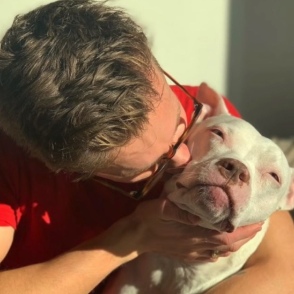 man kissing a deaf dog