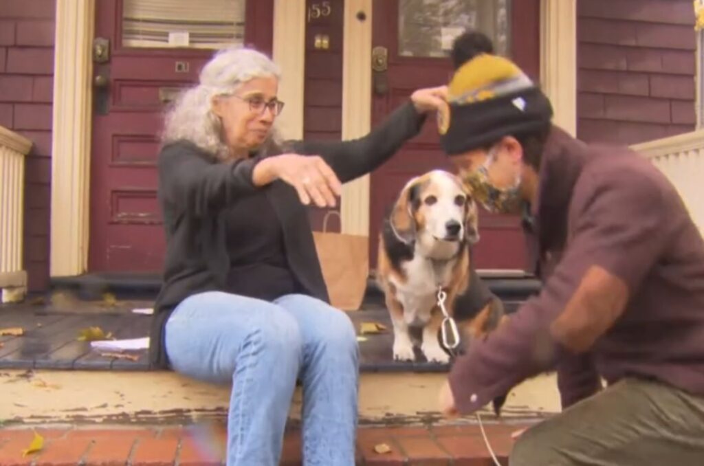 the dog watches as the man approaches the woman