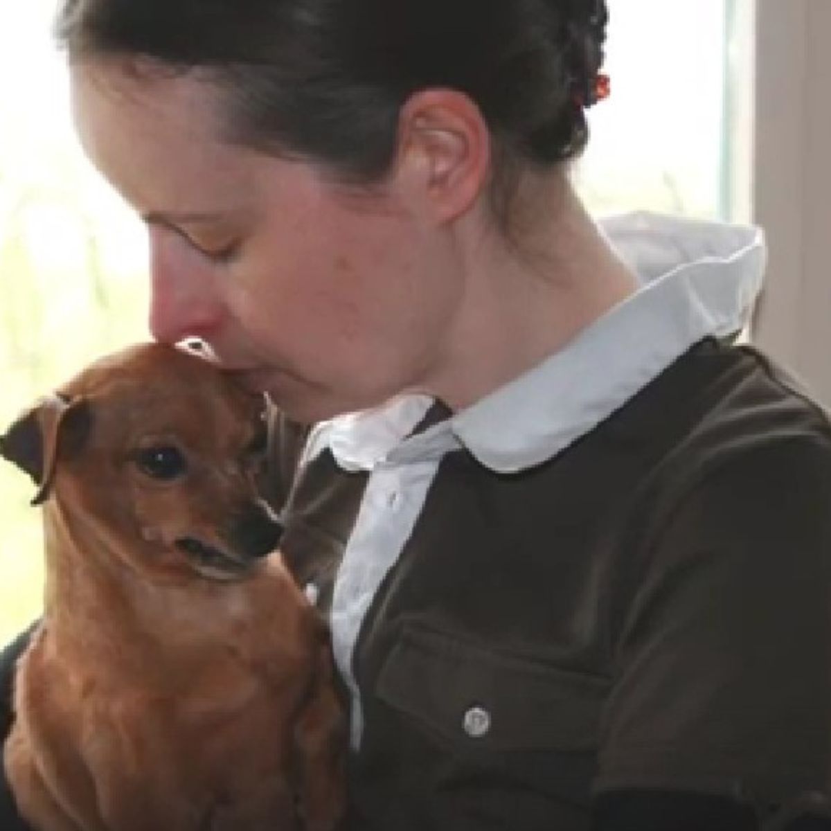 woman kissing a dog