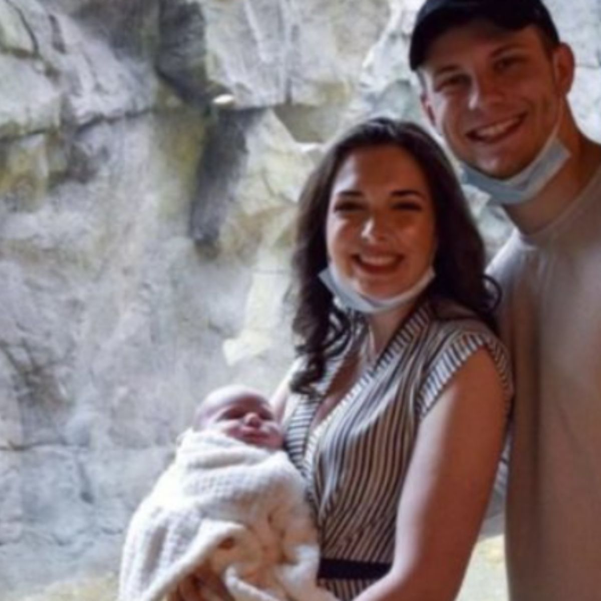 young couple with baby posing in zoo