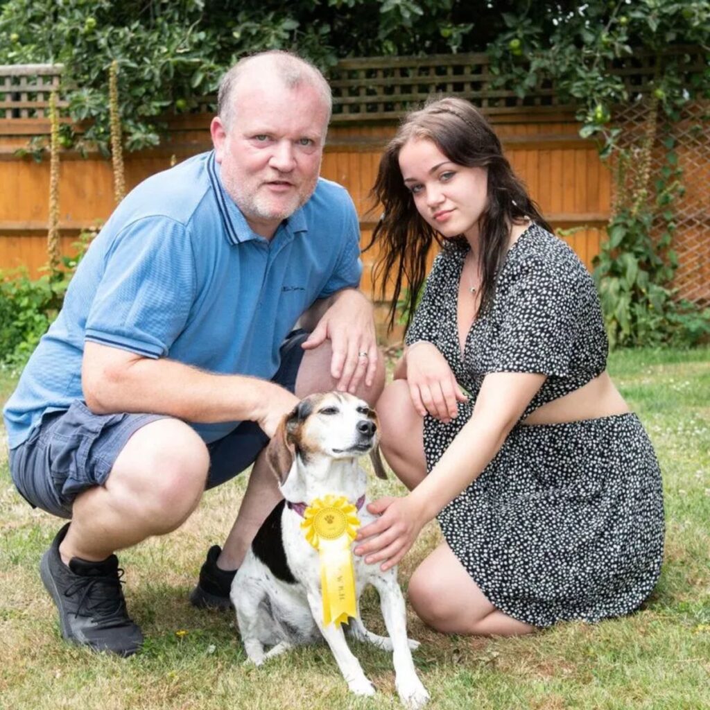 a man and a girl take a picture with a beagle