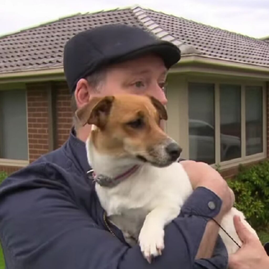 a man holds a dog in his arms