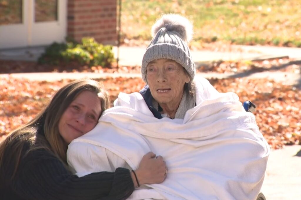 the girl hugs the old woman in the wheelchair and cries