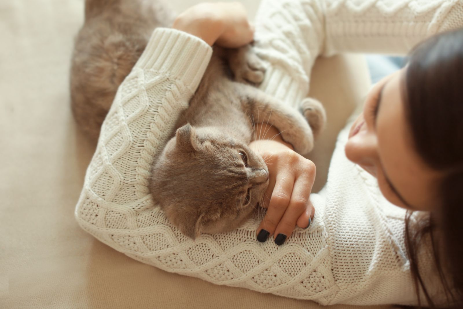 cat snuggled in owners embrace