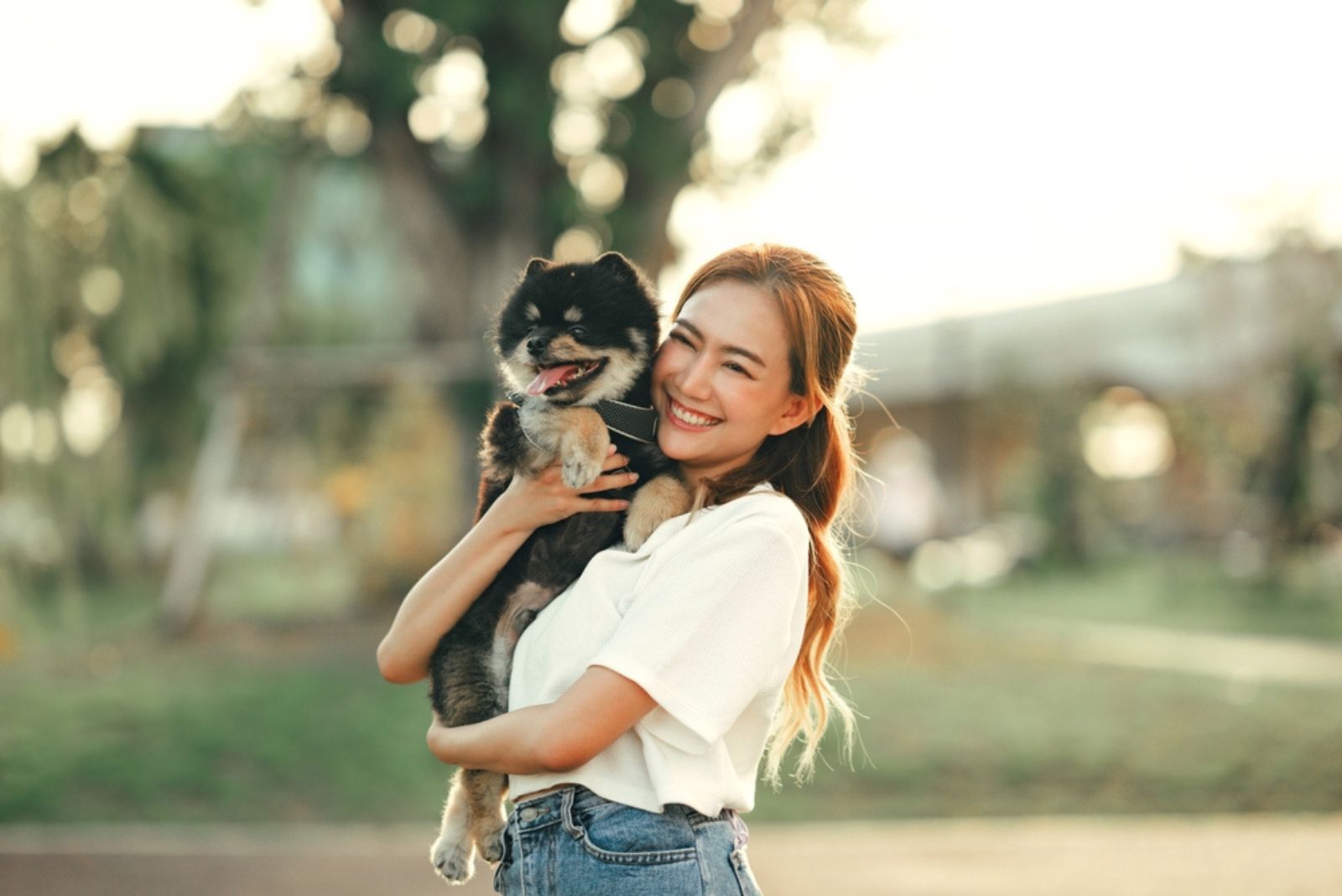 smiling woman holding her little dog