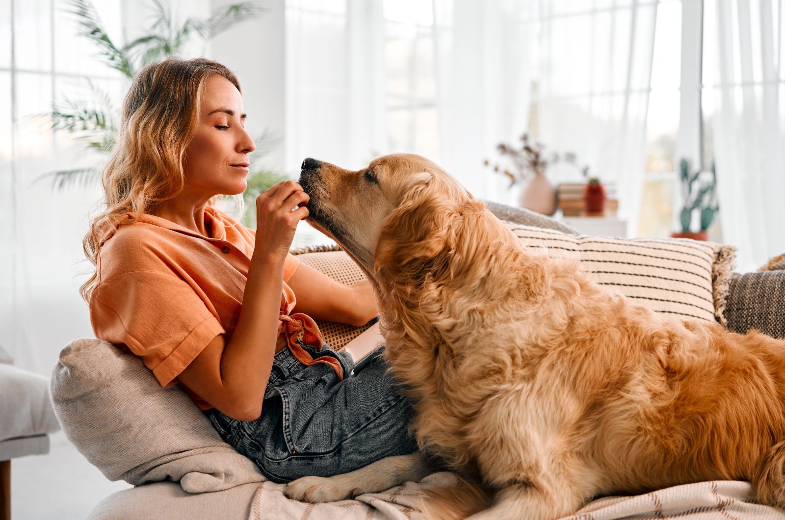 woman cuddling with dog on the couch