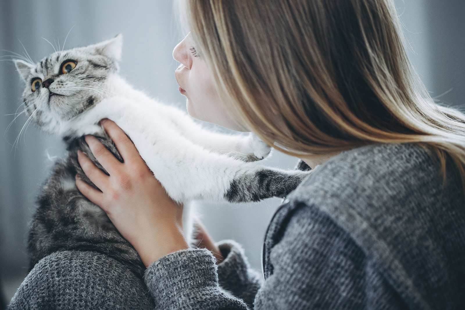 woman trying to kiss cat