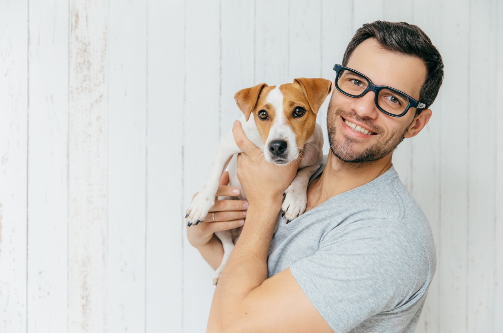 Man with glasses holding a dog