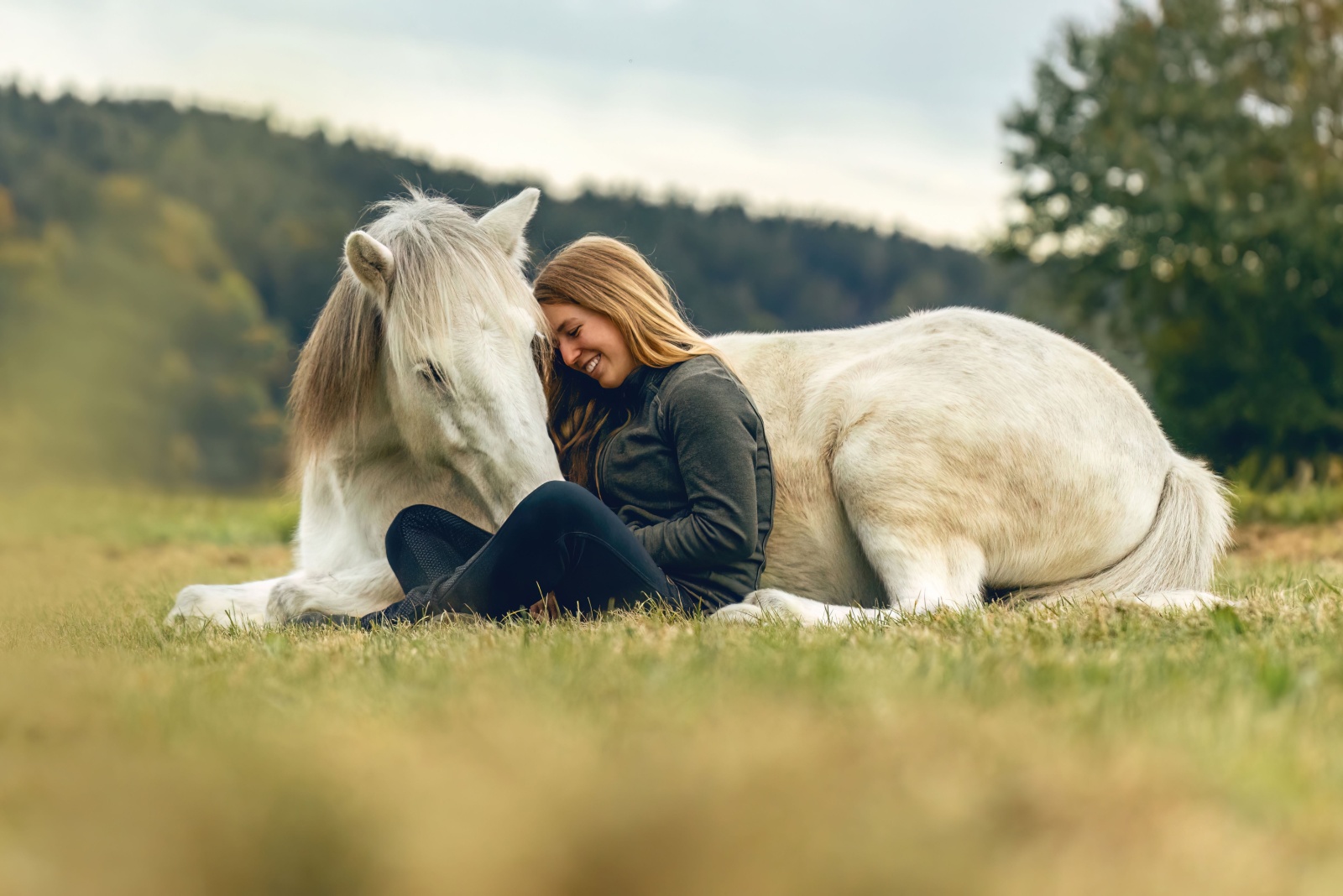 woman and a horse on a pasture