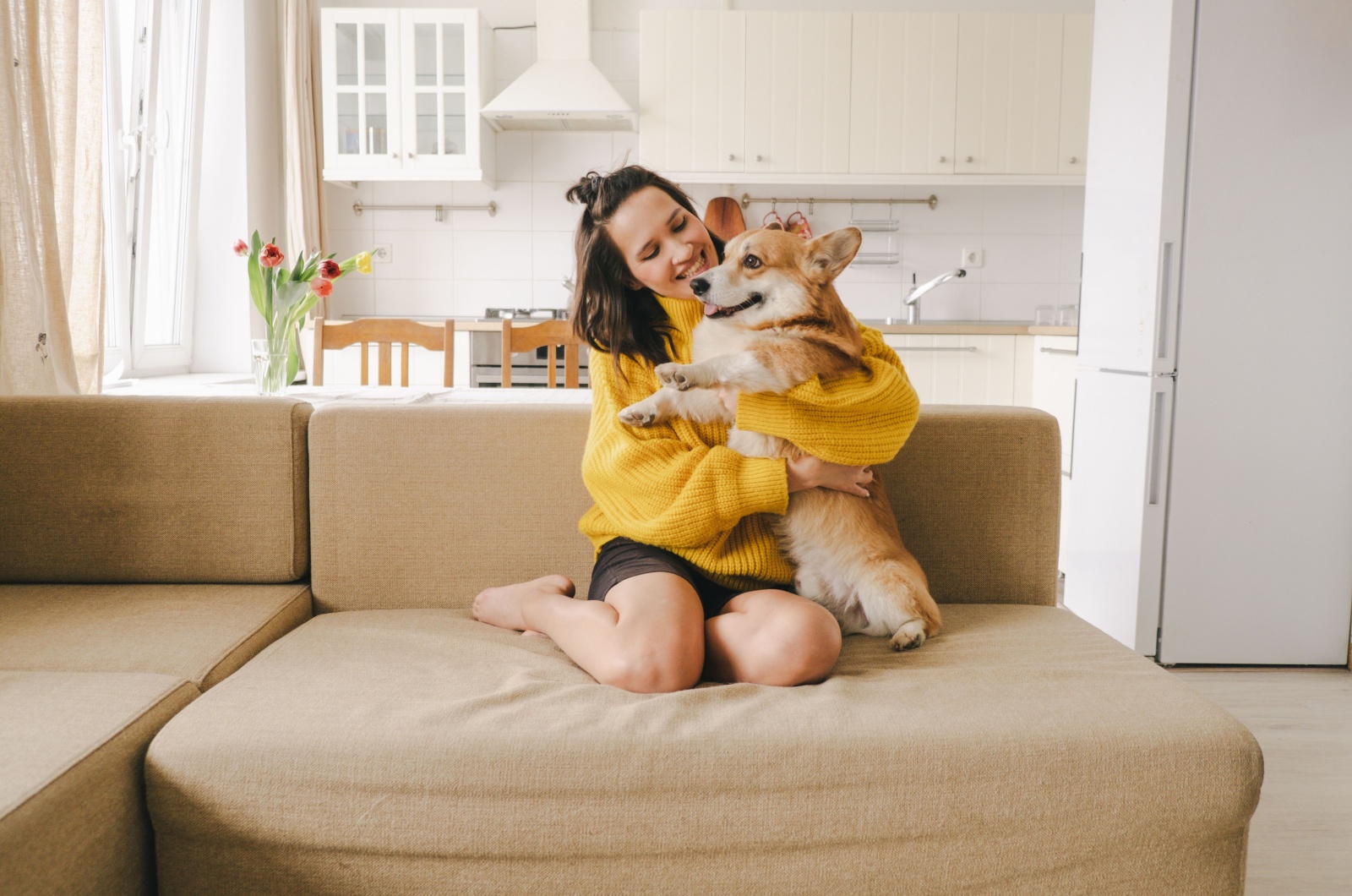 woman hugging dog on couch