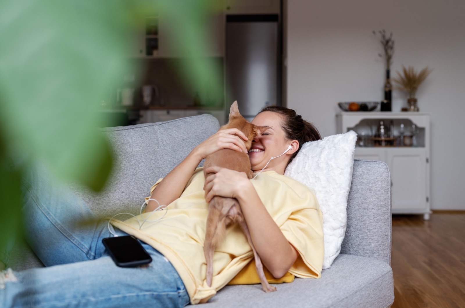 woman laying and hugging a dog