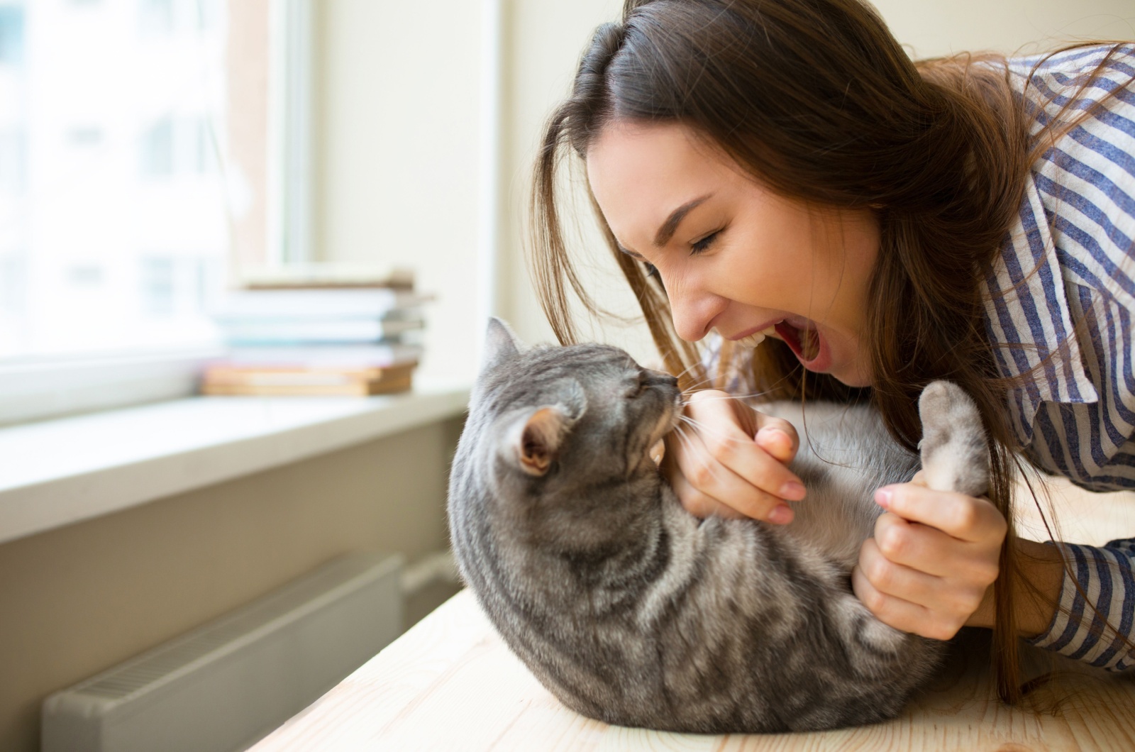 woman playing with cat