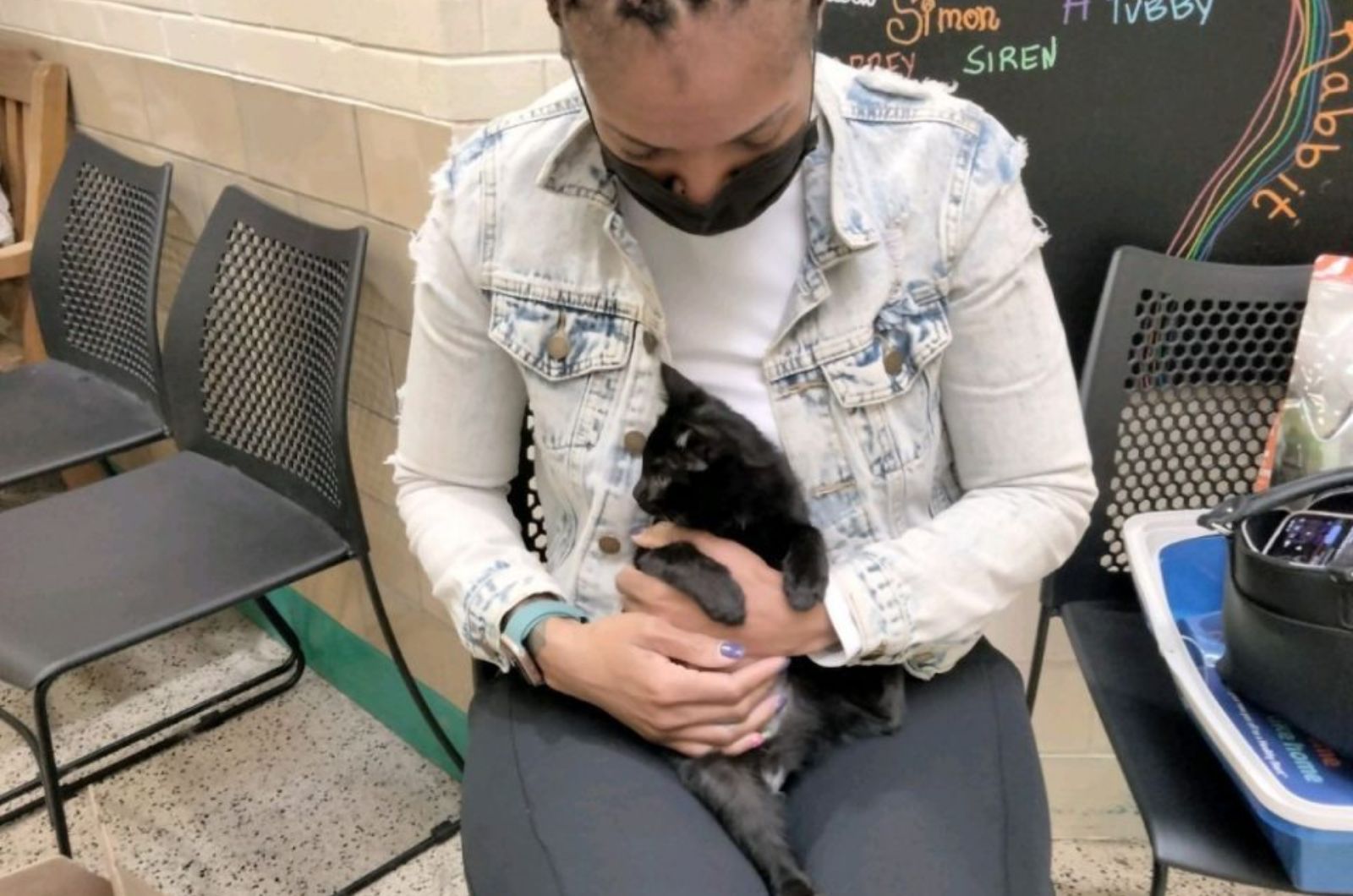 woman holding a black kitten